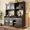A dark gray buffet cabinet with glass doors and gold accents, set against a light beige wall. Produktbild-Vorschau