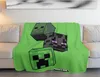 A Minecraft-themed blanket is draped over a sofa. Podgląd zdjęcia produktu