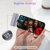 A person is holding a smartphone with a selfie displayed on the screen, while a portable charger is attached to the phone. Produktbild-Vorschau