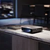 A modern living room setting with a projector on a marble table. Produktbild-Vorschau