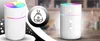 A collage-style image featuring two white humidifiers with colorful LED lights, and a circular icon of a humidifier in the center. Produktbild-Vorschau