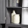 A close-up view of a gray cabinet interior, showing shelves with various items. Produktbild-Vorschau