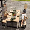 A couple enjoying a meal on a wooden deck with a table and benches. Náhled obrázku produktu