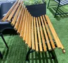A wooden slatted bench with a black metal frame sits on artificial grass. Produktbild-Vorschau