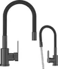 Two black kitchen faucets are shown against a white background. One faucet is larger and positioned on the left, while a smaller one is on the right, with water flowing from its spout. Podgląd zdjęcia produktu