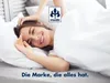 A woman is smiling and stretching in bed under white sheets. Produktbild-Vorschau
