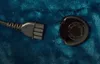 A close-up view of a power plug and its socket on a teal fabric. Produktbild-Vorschau