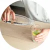 A person is pouring liquid from a SodaStream bottle into a glass with lime and mint. Produktbild-Vorschau