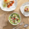 A table setting with plates of food and cutlery. Produktbild-Vorschau
