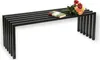 A black metal bench with a book and a bouquet of flowers on top, set against a white background. Produktbild-Vorschau