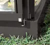 A close-up view of the base and corner of a dark grey greenhouse frame, with green grass in the foreground and background. Produktbild-Vorschau