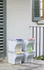 Four stacked recycling bins with different colored lids are placed on a patio next to a building. Náhľad obrázku produktu