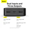 A close-up view of a black power bank with its ports visible, accompanied by a diagram explaining its input and output specifications. Podgląd zdjęcia produktu