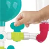 A child's hand is shown turning a valve on a water experiment lab toy. Produktbild-Vorschau