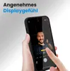 A hand holding a smartphone, showing the camera interface with a person in the frame. Produktbild-Vorschau