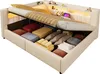 A bed with its storage compartment open, showing various items stored inside. Produktbild-Vorschau