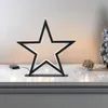 A decorative LED star light sits on a mantelpiece with festive decorations. Produktbild-Vorschau