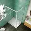 A modern bathroom with a corner shower enclosure, sink, and window. Produktbild-Vorschau