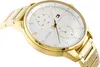 A close-up, angled shot of a gold Tommy Hilfiger watch with a white face. Produktbild-Vorschau