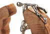 A close-up of a decorative figurine made of wood and metal, depicting a stylized human figure climbing or interacting with wooden elements. Náhled obrázku produktu