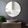 A modern bathroom with a round mirror above a sink and vanity. Anteprima dell’immagine prodotto