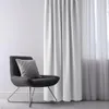 A modern chair with a pillow next to a white curtain. Produktbild-Vorschau