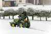 A child is riding a toy tractor in the snow. Produktbild-Vorschau