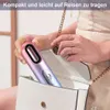 A person is placing a hair dryer into a white purse. Produktbild-Vorschau