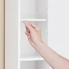 A hand is shown adjusting a shelf inside a white cabinet. Náhled obrázku produktu