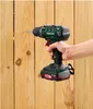 A hand is holding a cordless drill and drilling a hole in a wooden fence. Produktbild-Vorschau