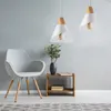 A modern living room setting with a chair, side table, and pendant lights. Produktbild-Vorschau