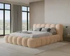A bedroom with a large, upholstered bed and large windows overlooking a natural landscape. Voir les images du produit