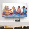 A group of friends enjoying a day at the beach, with a laptop connected to a large TV displaying the same scene. Anteprima dell’immagine prodotto