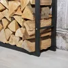 A close-up view of a metal firewood rack filled with logs, placed on a light wooden floor next to a textured wall. Podgląd zdjęcia produktu