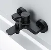 A black bathroom faucet mounted on a white wall above a white bathtub. Produktbild-Vorschau