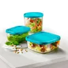 Three glass food storage containers with turquoise lids are arranged on a white surface. Produktbild-Vorschau