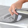 A hand is shown adjusting a gray cushion on a white shelf. Produktbild-Vorschau