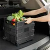 A person is placing a black folding shopping trolley filled with fresh vegetables into the trunk of a car. Anteprima dell’immagine prodotto
