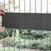 Hands are shown attaching a dark gray privacy screen to a wire fence. Anteprima dell’immagine prodotto