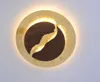 A circular decorative lamp with a gold outer ring and a dark inner circle with a torn, illuminated section. Produktbild-Vorschau