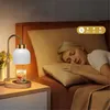 A woman sleeping in bed next to a bedside table with a candle warmer lamp. Náhled obrázku produktu