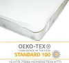 A close-up view of a mattress protector on a mattress, with a certification logo below. Produktbild-Vorschau