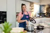 A woman is cooking in a modern kitchen. Produktbild-Vorschau