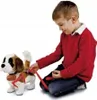 A young boy is playing with a stuffed dog on a leash. Produktbild-Vorschau