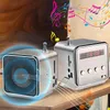 Two silver cube-shaped mini-speakers are shown on a wooden surface, with colorful musical notes and sound waves emanating from them. Produktbild-Vorschau