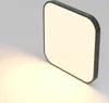 A square LED ceiling light with rounded corners, casting a warm light onto a gray surface. Voir les images du produit