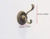 A bronze vintage wall hook mounted on a white wall, with dimensions indicated by red lines and text. Produktbild-Vorschau