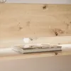 A close-up of a wooden shelf with a book on it and a light source behind it. Produktbild-Vorschau