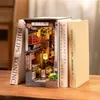 A 3D wooden book nook designed to look like a Japanese alleyway, placed between two books on a wooden surface. Voir les images du produit