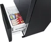 A close-up view of an open freezer drawer in a black refrigerator, filled with ice and frozen food items. Produktbild-Vorschau